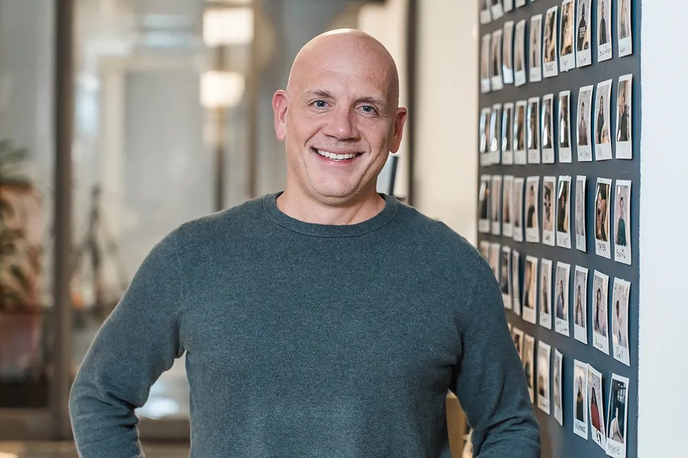 Professional environmental office headshot of employee photographed in workplace setting during corporate portrait session in New York office